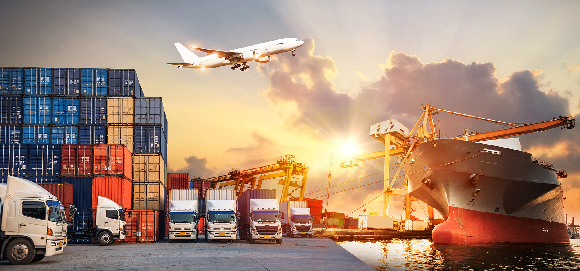 Containers, trucks, a ship and an aircraft at a freight terminal